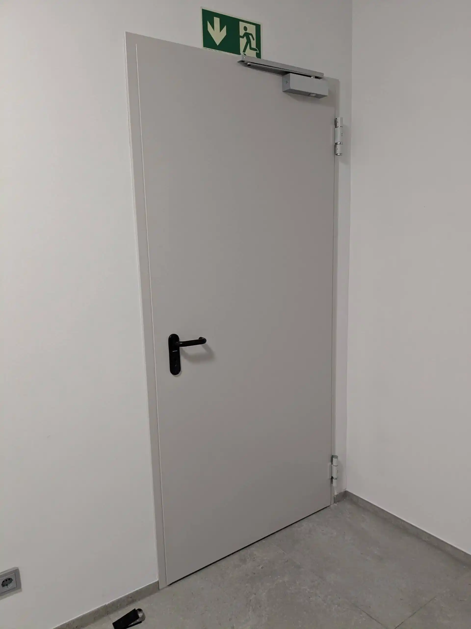 Fluchttür mit Fluchtwegschild und Obenschließer im Objekt